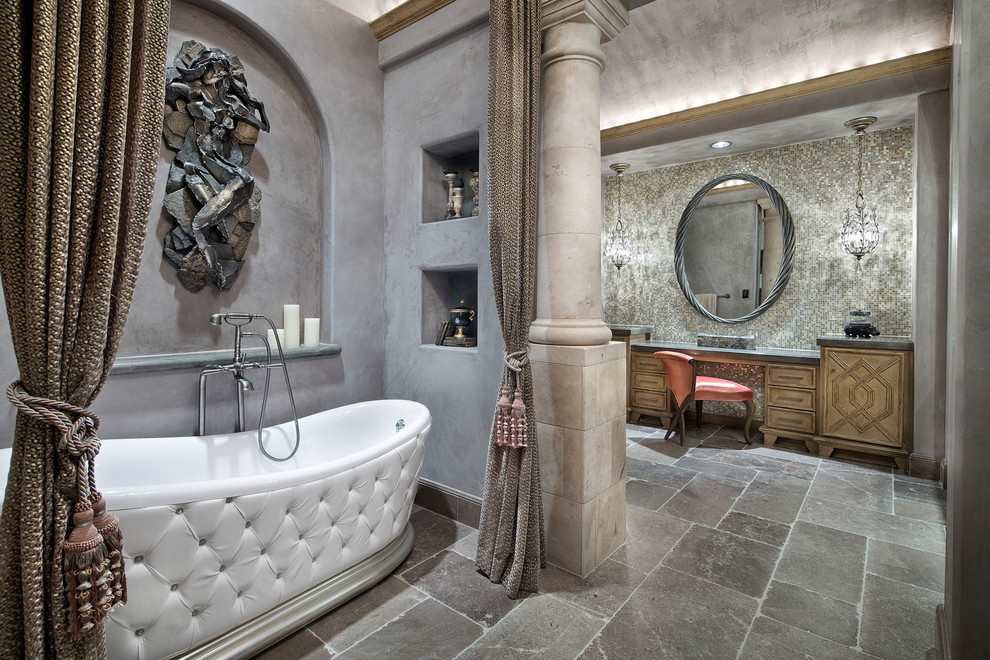 Expansive mediterranean master bathroom in Houston with recessed-panel cabinets, light wood cabinets, a freestanding tub, multi-coloured tile, mosaic tile, multi-coloured walls, granite benchtops, green benchtops, marble floors and brown floor.