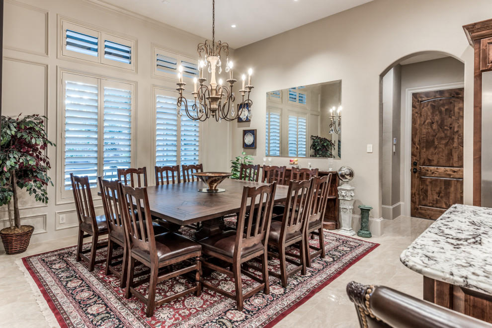 This is an example of a traditional dining room in Houston with grey walls, no fireplace and beige floor.