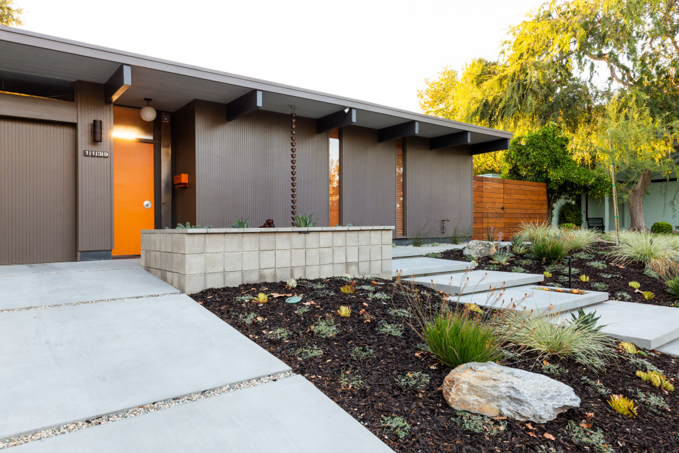 Ispirazione per un giardino minimalista esposto in pieno sole di medie dimensioni e davanti casa in estate con pavimentazioni in cemento e recinzione in pietra