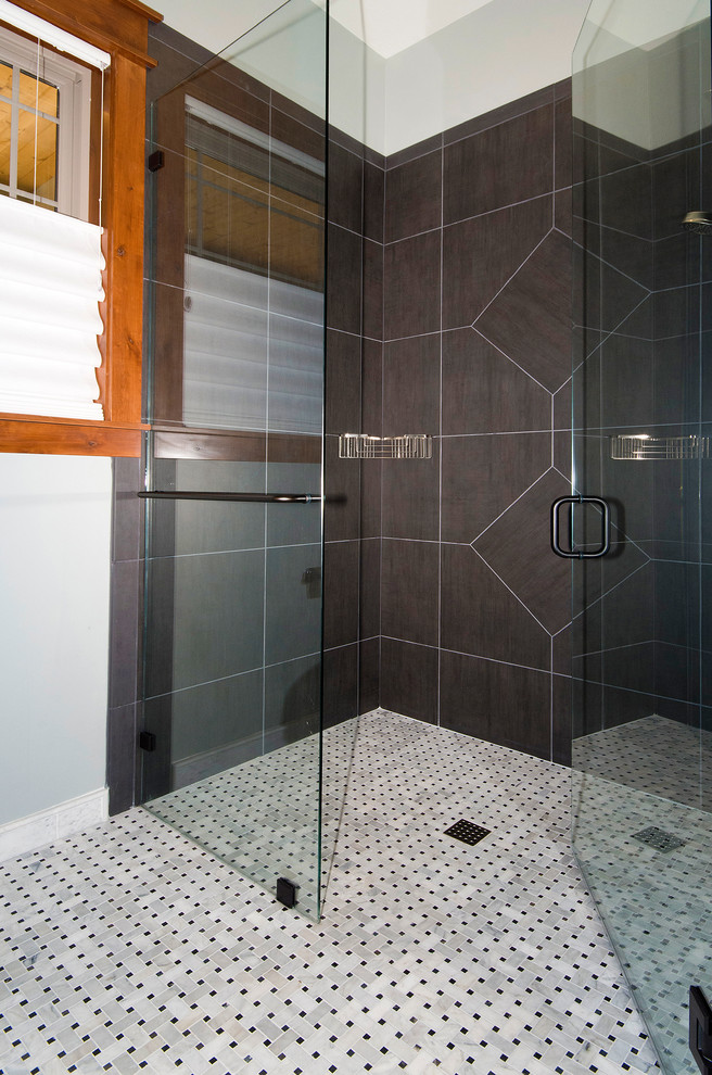 This is an example of a large arts and crafts master bathroom in Denver with a corner shower, grey walls, marble floors and a hinged shower door.