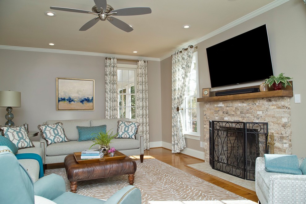 Inspiration for a mid-sized traditional open concept family room in Raleigh with grey walls, medium hardwood floors, a standard fireplace, a stone fireplace surround and a wall-mounted tv.