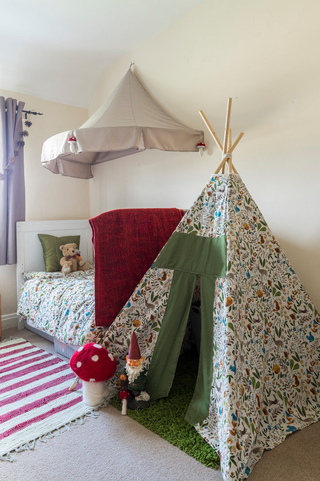 Mid-sized contemporary gender-neutral kids' bedroom in London with carpet and beige floor for kids 4-10 years old.