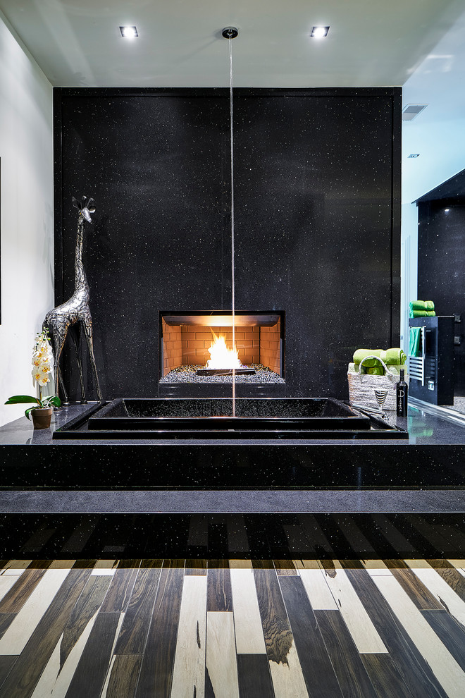 Example of a minimalist black tile and stone tile porcelain tile drop-in bathtub design in Charleston