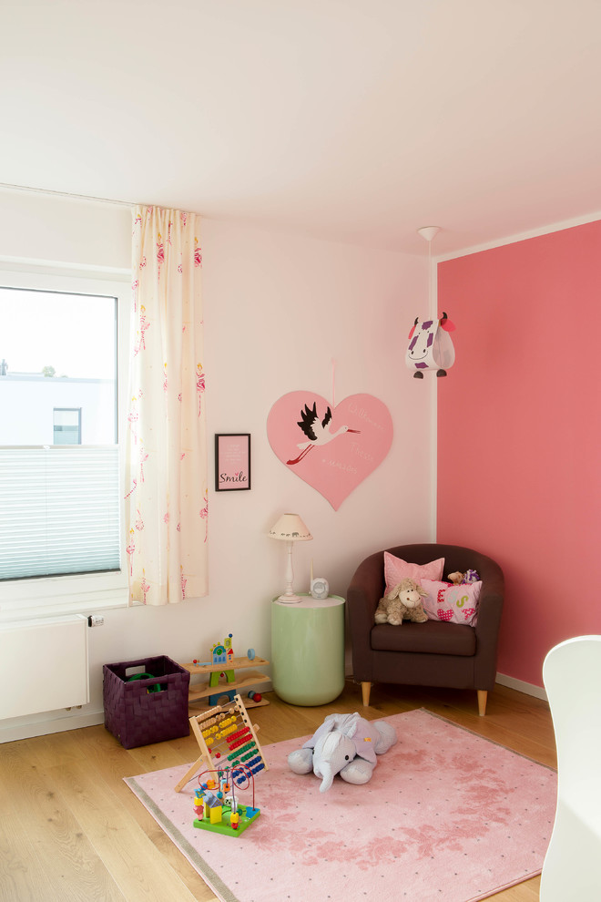 Mädchenzimmer mit rosa Wandfarbe und hellem Holzboden in Dusseldorf