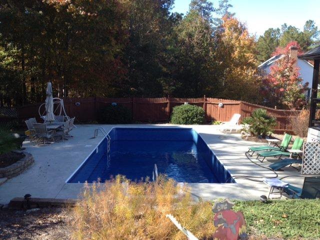 Example of a backyard stamped concrete and rectangular pool design
