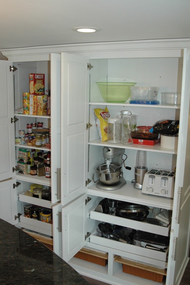 Example of a mid-sized transitional l-shaped medium tone wood floor and brown floor enclosed kitchen design in Boston with an undermount sink, recessed-panel cabinets, white cabinets, granite countertops, multicolored backsplash, glass tile backsplash, stainless steel appliances and an island