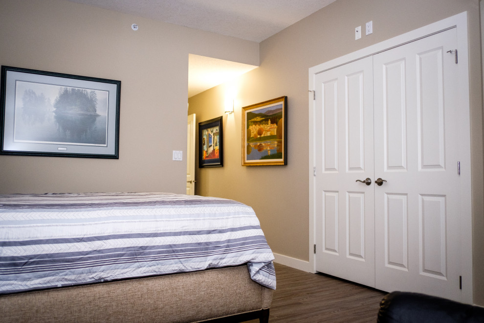 Photo of a mid-sized transitional gender-neutral built-in wardrobe in Edmonton with vinyl floors and multi-coloured floor.