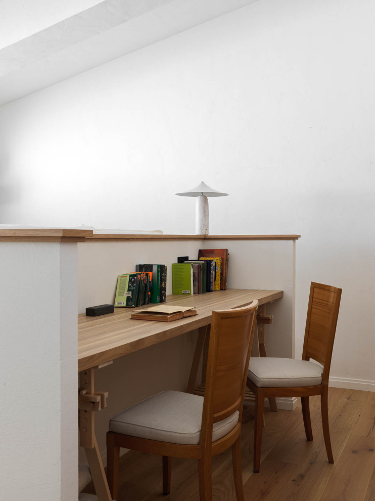 Modelo de despacho clásico renovado con paredes blancas, suelo de madera en tonos medios y suelo marrón