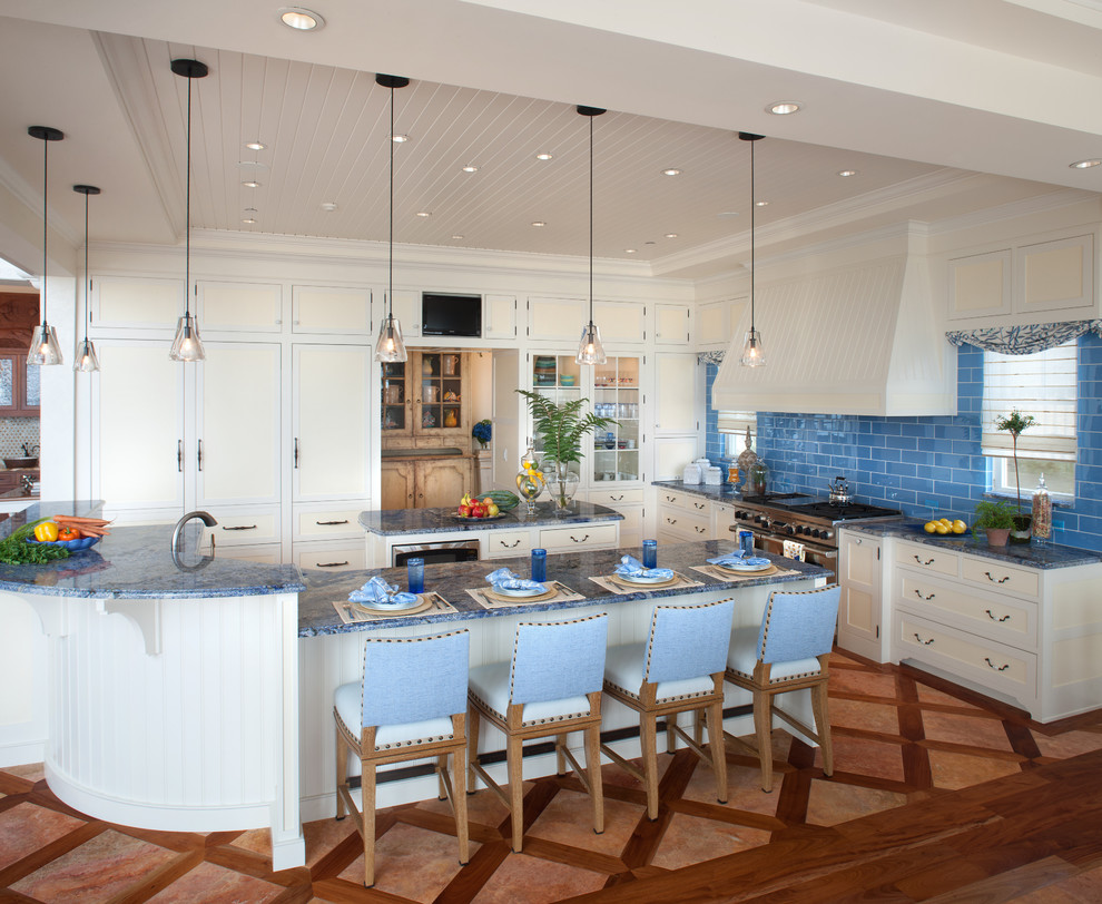 Photo of a beach style u-shaped open plan kitchen in DC Metro with recessed-panel cabinets, beige cabinets, blue splashback, subway tile splashback, panelled appliances and blue benchtop.