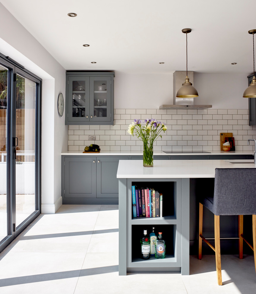 Mid-sized transitional kitchen in Surrey with grey cabinets, quartzite benchtops, white splashback, subway tile splashback, with island, white benchtop, an undermount sink, glass-front cabinets and grey floor.