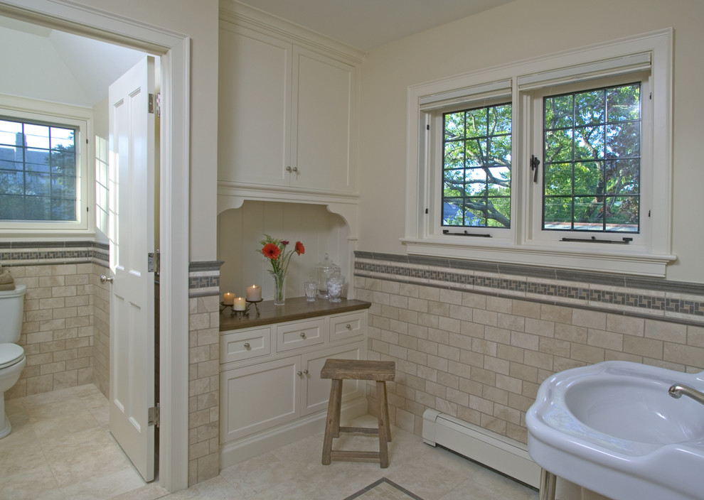 Photo of a traditional bathroom in Boston with subway tile, recessed-panel cabinets, white cabinets, beige tile and wood benchtops.