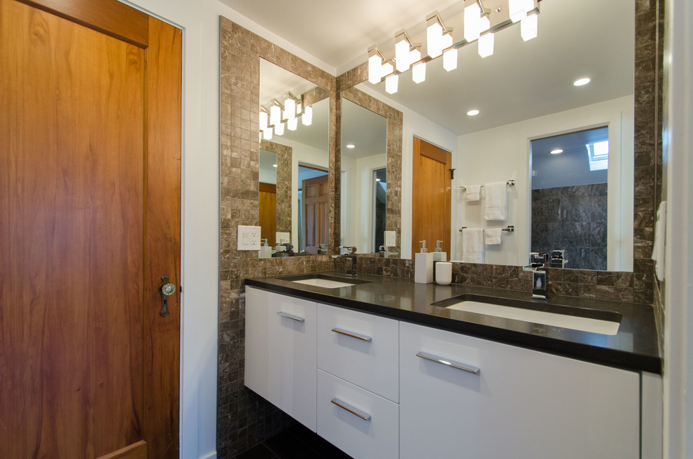 This is an example of a small modern master bathroom in New York with flat-panel cabinets, white cabinets, a drop-in tub, an alcove shower, a two-piece toilet, brown tile, white walls, porcelain floors, an undermount sink, black floor, a hinged shower door, porcelain tile and engineered quartz benchtops.