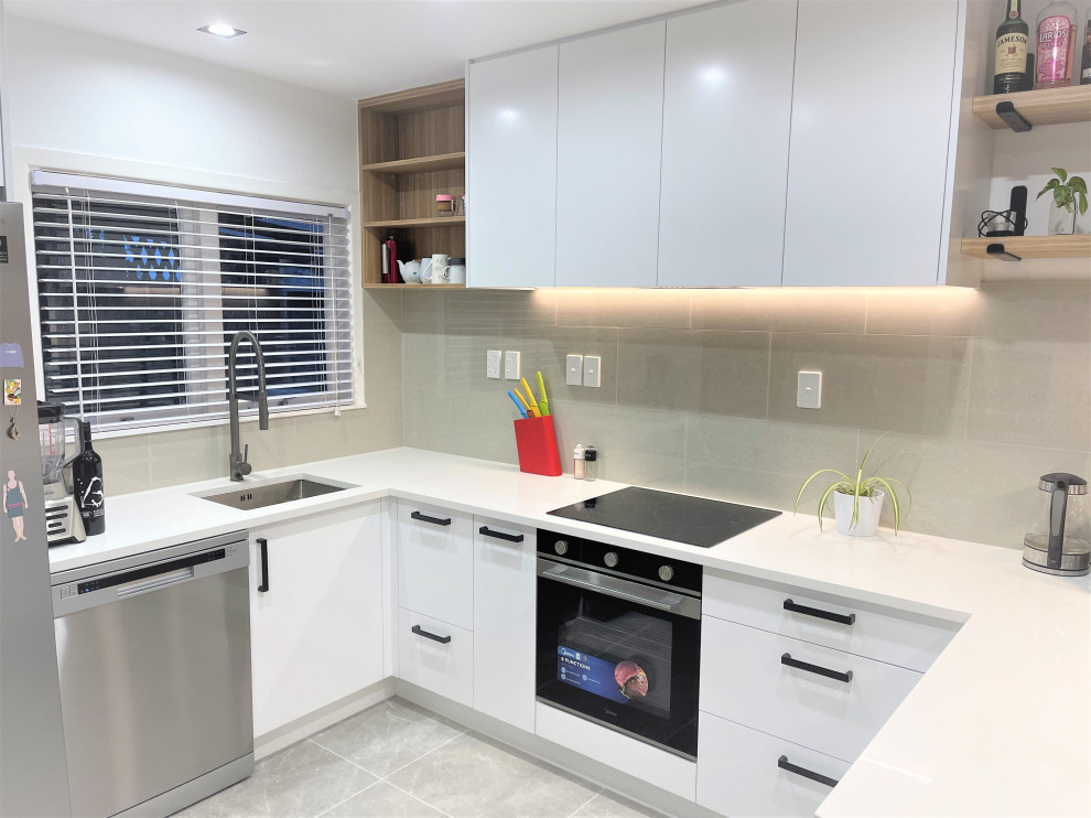 Exempel på ett mellanstort modernt vit vitt kök, med en enkel diskho, släta luckor, vita skåp, bänkskiva i kvarts, grått stänkskydd, stänkskydd i stickkakel, rostfria vitvaror, klinkergolv i porslin och grått golv