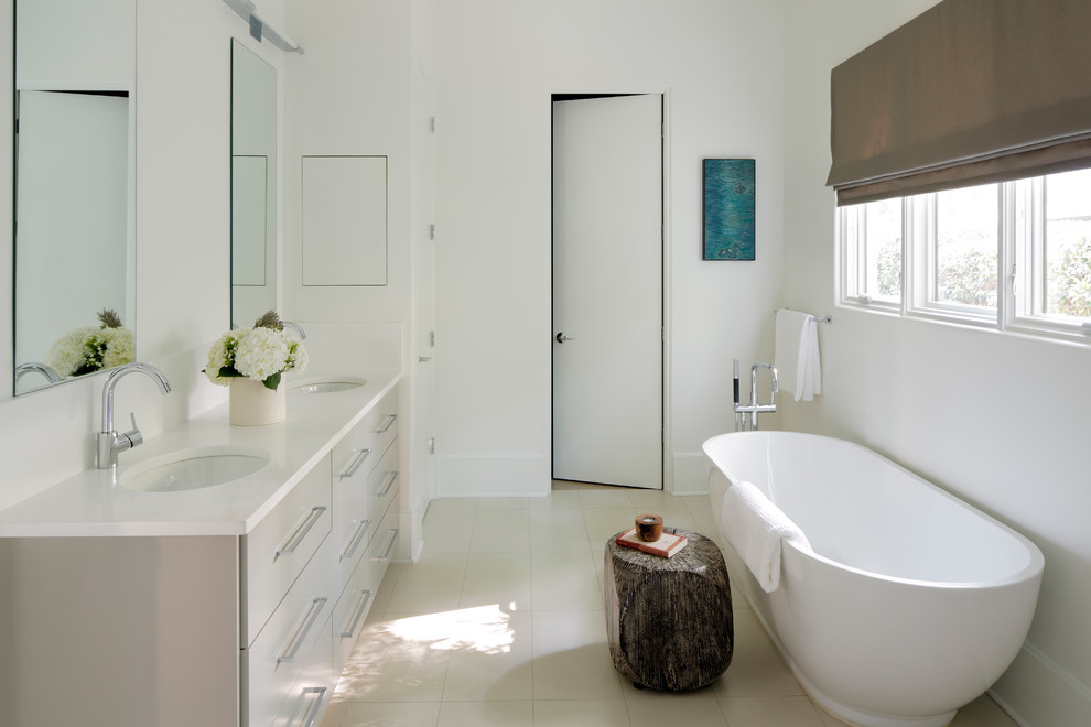 This is an example of a mid-sized transitional master bathroom in Atlanta with an undermount sink, grey cabinets, engineered quartz benchtops, a freestanding tub, white tile and white walls.