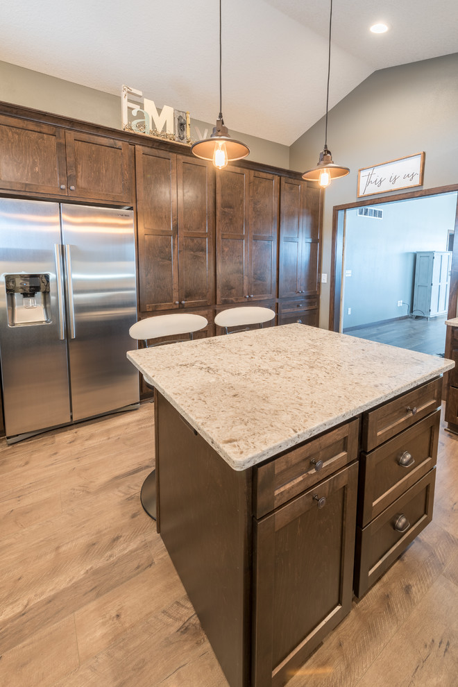 Inspiration for a large rustic u-shaped dark wood floor and brown floor enclosed kitchen remodel in Minneapolis with a double-bowl sink, shaker cabinets, dark wood cabinets, granite countertops, white backsplash, subway tile backsplash, stainless steel appliances and an island