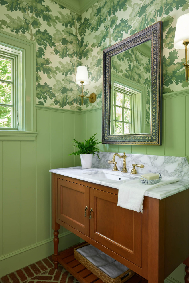 Exempel på ett klassiskt vit vitt toalett, med luckor med infälld panel, skåp i mellenmörkt trä, gröna väggar, tegelgolv, ett undermonterad handfat och rött golv