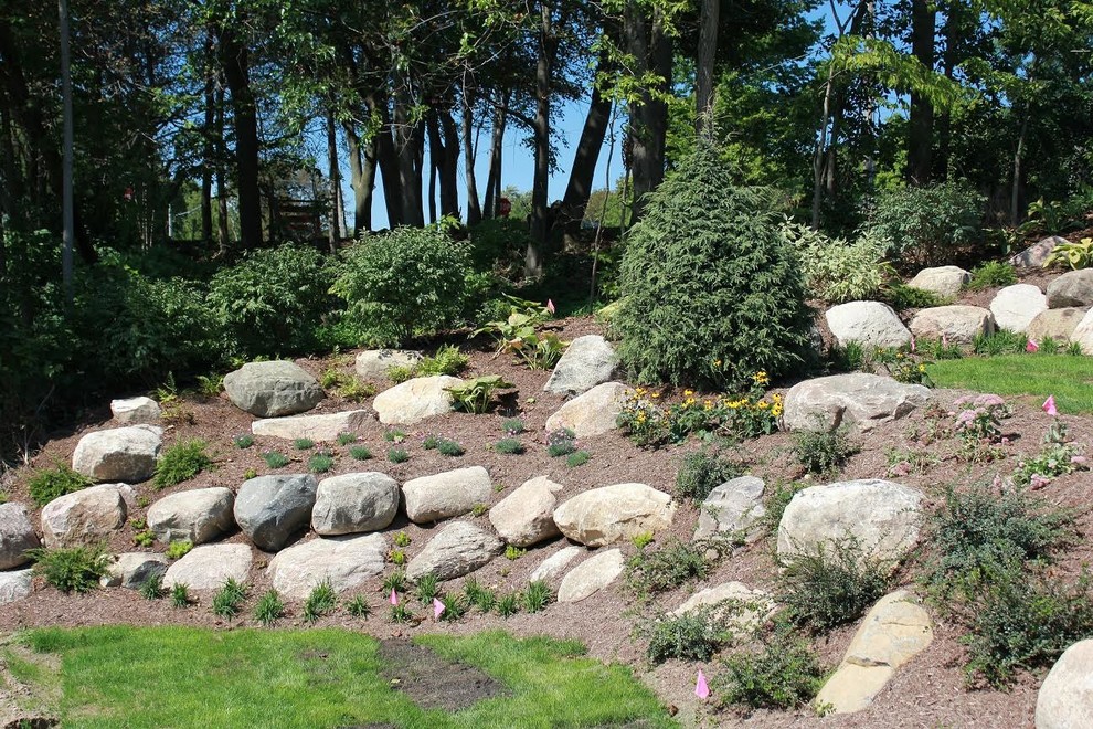 Photo of a large arts and crafts backyard full sun garden in Other with a water feature and mulch.