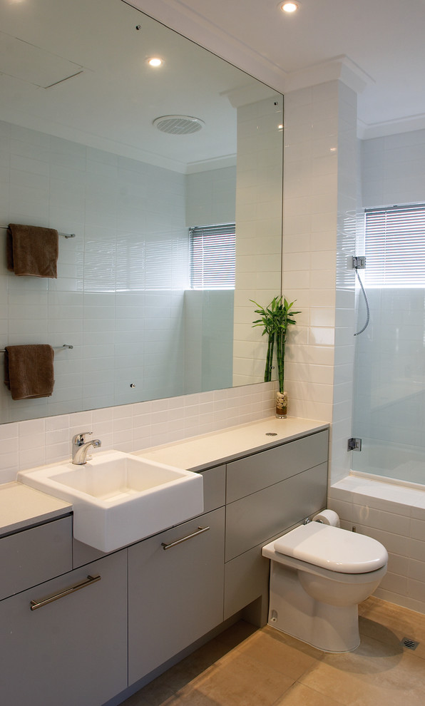 Contemporary bathroom in Perth with flat-panel cabinets, an alcove tub, a shower/bathtub combo, a wall-mount toilet, white tile, ceramic tile, white walls, ceramic floors, a wall-mount sink and granite benchtops.