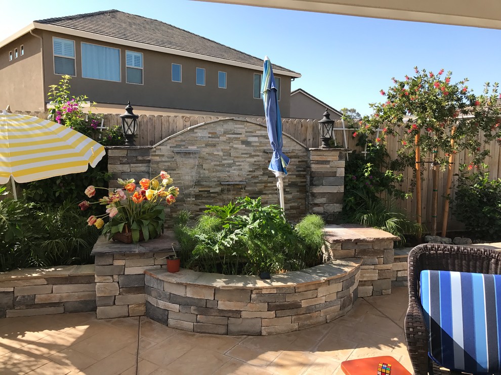 Photo of a mid-sized transitional partial sun backyard stone formal garden.