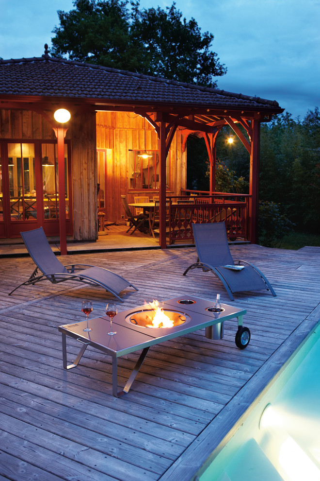 Inspiration for a mid-sized contemporary side yard deck in Rennes with a fire feature.