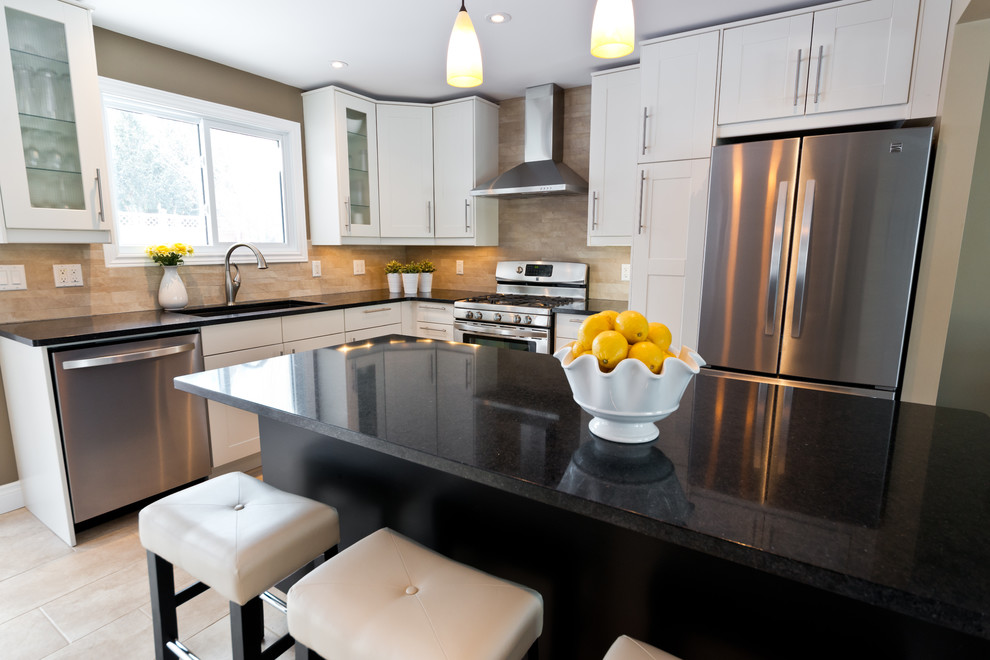 Kitchen photo in Ottawa with an undermount sink, white cabinets, beige backsplash, mosaic tile backsplash, stainless steel appliances and an island