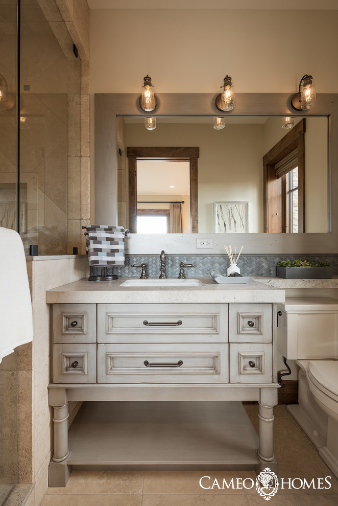 Design ideas for a large traditional 3/4 bathroom in Salt Lake City with beaded inset cabinets, distressed cabinets, an alcove shower, a two-piece toilet, gray tile, white walls, porcelain floors, an undermount sink and soapstone benchtops.