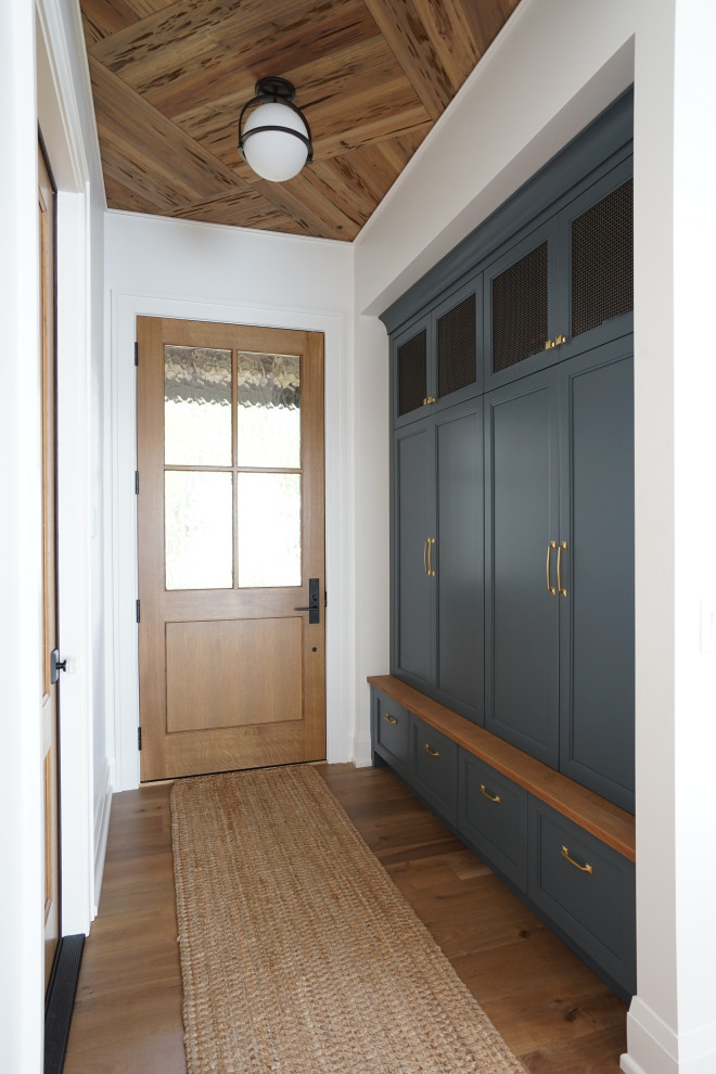 Ispirazione per un ingresso con anticamera tradizionale di medie dimensioni con pareti bianche, pavimento in legno massello medio, una porta singola, una porta in legno bruno, pavimento marrone e soffitto in legno