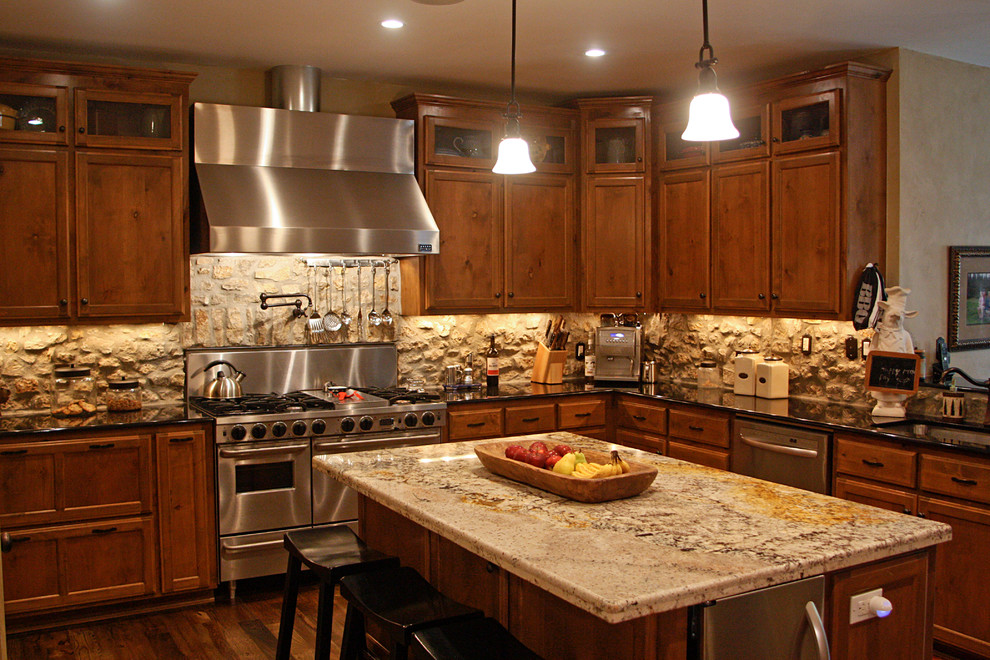 Inspiration for a large rustic u-shaped medium tone wood floor open concept kitchen remodel with recessed-panel cabinets, medium tone wood cabinets, granite countertops, beige backsplash, stone tile backsplash, stainless steel appliances and two islands