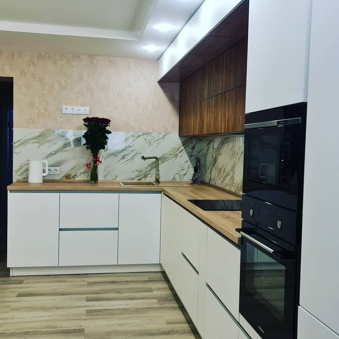 Уютная угловая кухня с фасадами под дерево и серыми матовыми фасадами