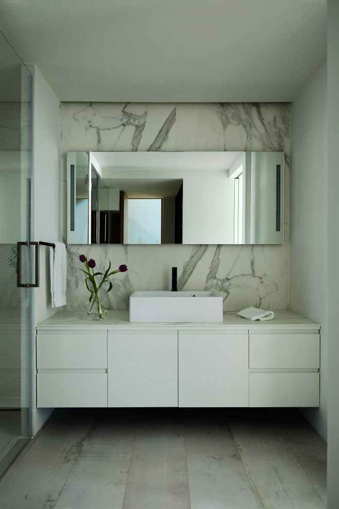 Inspiration for a contemporary bathroom in Other with flat-panel cabinets, white cabinets, white tile, stone slab, white walls, a vessel sink, grey floor and white benchtops.