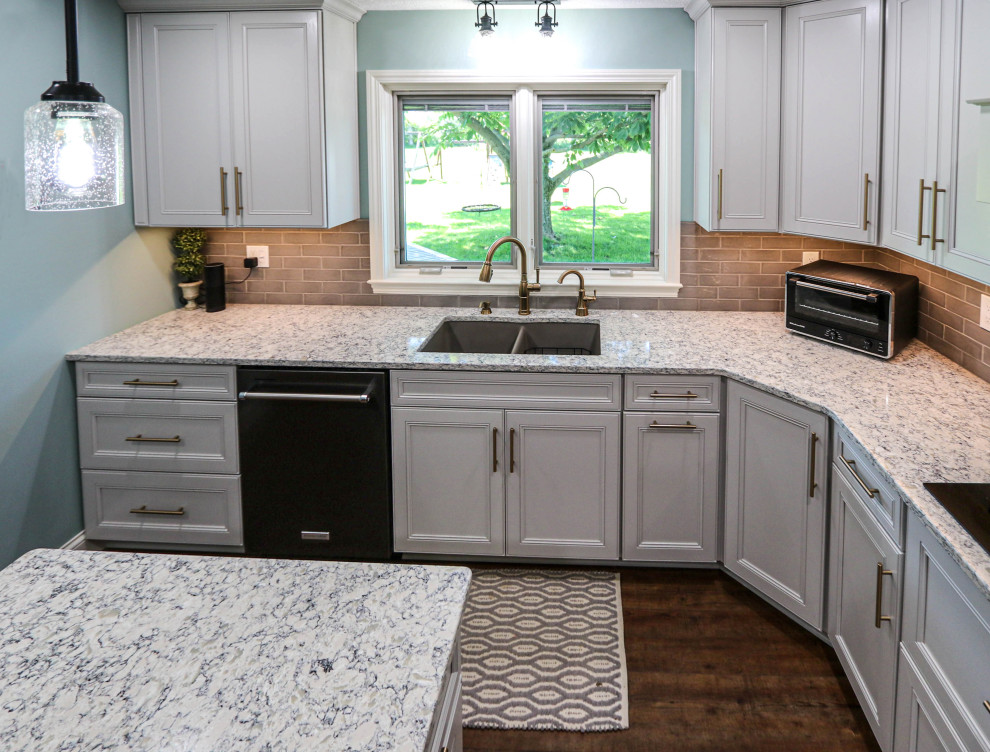 Example of a mid-sized transitional l-shaped kitchen pantry design in Cleveland with flat-panel cabinets, gray cabinets, quartz countertops, gray backsplash, ceramic backsplash, an island and multicolored countertops