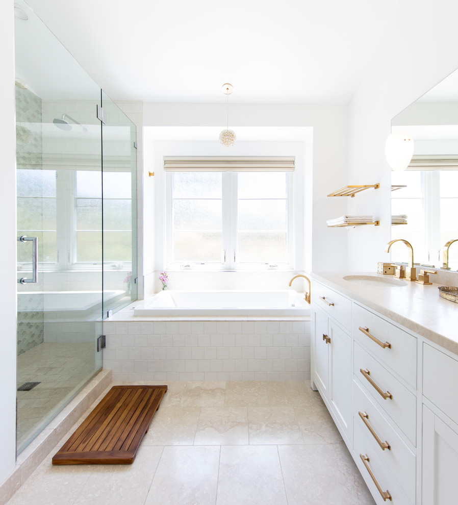 This is an example of a contemporary master bathroom in San Francisco with flat-panel cabinets, white cabinets, a drop-in tub, an alcove shower, multi-coloured tile, white walls, an undermount sink, beige floor, a hinged shower door and beige benchtops.