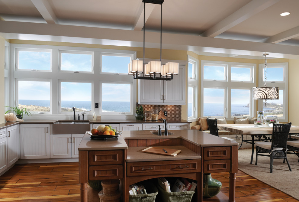 Inspiration for a large transitional l-shaped eat-in kitchen in San Francisco with a farmhouse sink, beaded inset cabinets, white cabinets, brown splashback, glass tile splashback, stainless steel appliances, medium hardwood floors, with island and brown floor.