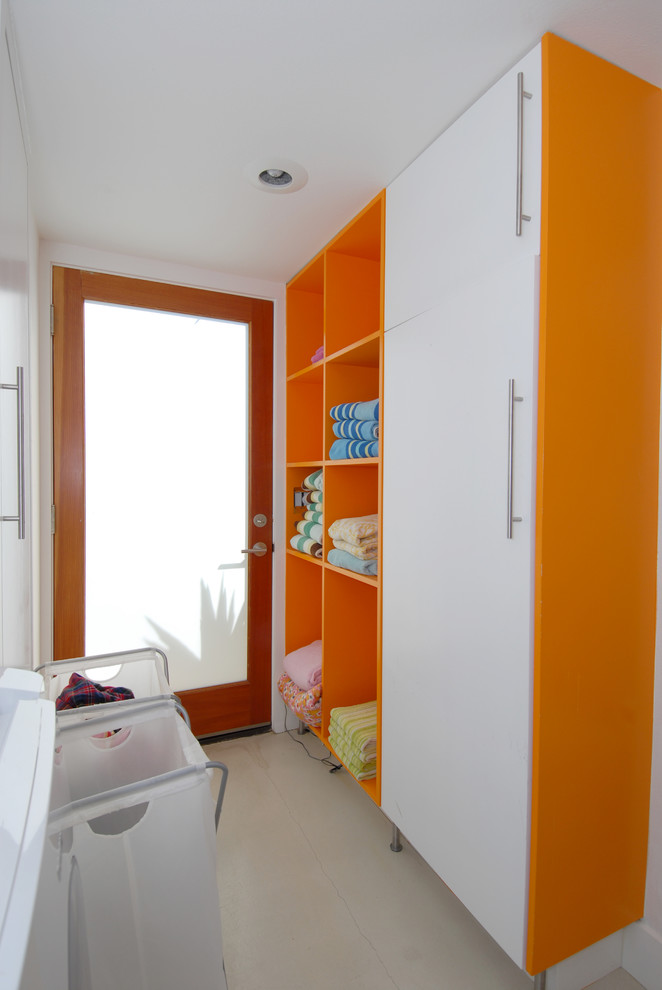 Photo of a contemporary galley laundry room in Orange County with open cabinets and orange cabinets.