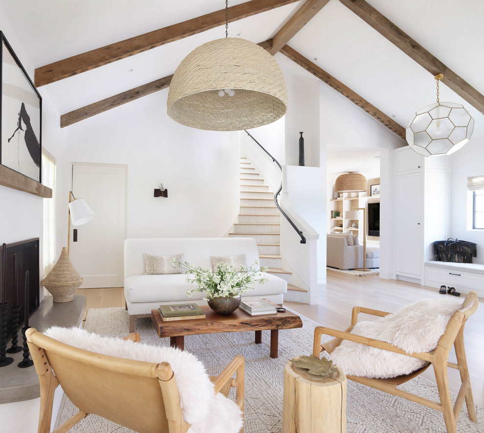Expansive transitional open concept living room in San Francisco with white walls, light hardwood floors, a standard fireplace, a plaster fireplace surround, no tv, beige floor and exposed beam.