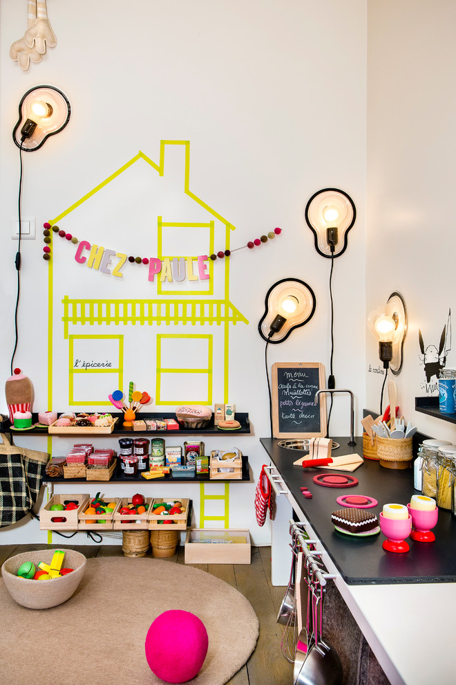 Inspiration for a mid-sized contemporary gender-neutral kids' playroom for kids 4-10 years old in Paris with white walls and medium hardwood floors.
