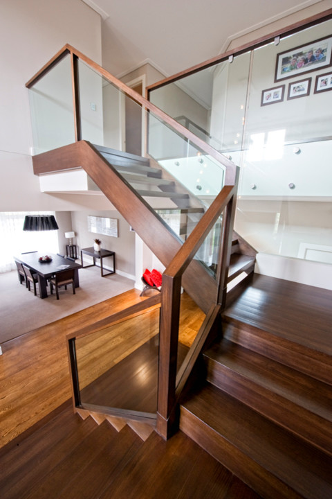 This is an example of a large contemporary wood u-shaped staircase in Melbourne with open risers.