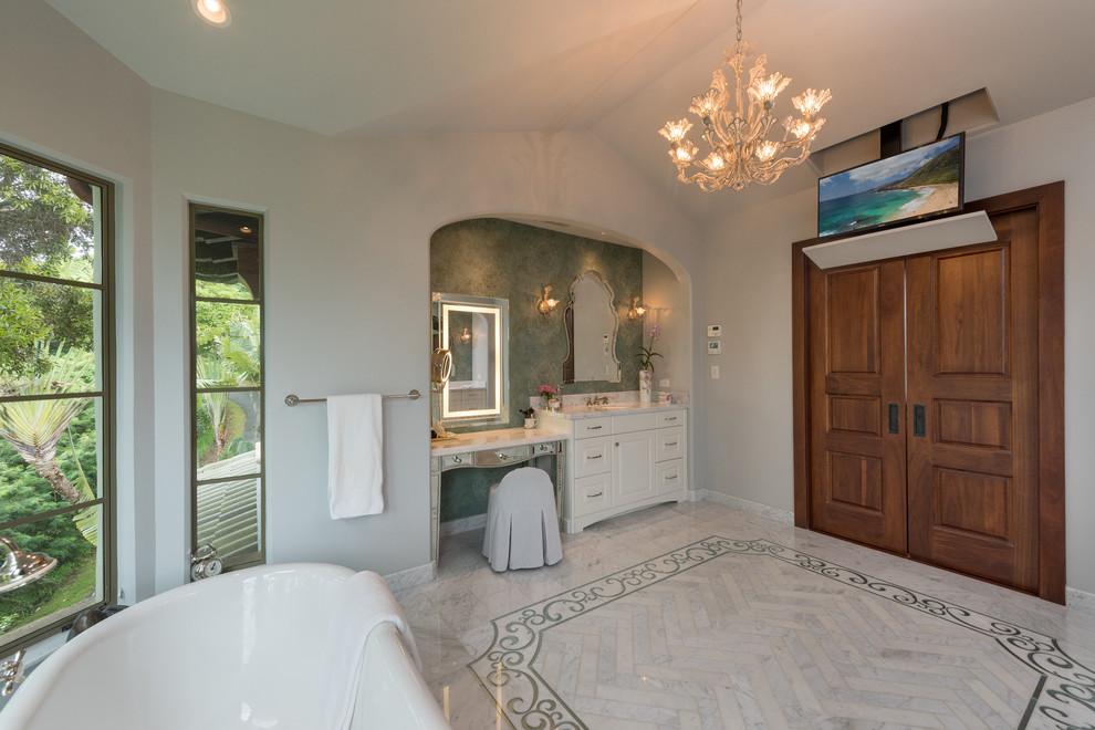 Photo of a large mediterranean master bathroom in Hawaii with raised-panel cabinets, white cabinets, a freestanding tub, an open shower, green walls and an undermount sink.