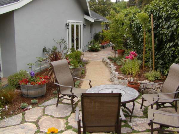 Small mediterranean side yard patio in San Francisco with natural stone pavers and no cover.