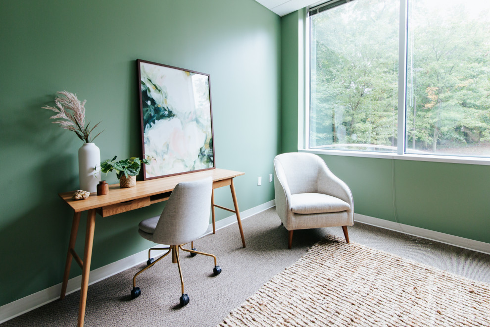 Cette photo montre un très grand bureau moderne avec un mur vert et un sol marron.