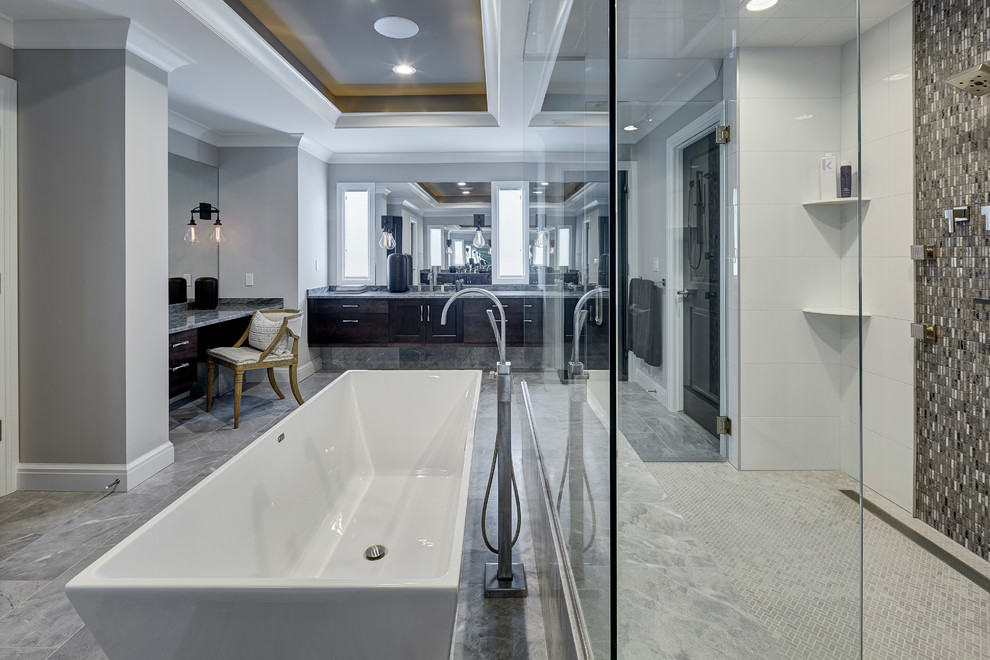Inspiration for a large transitional master bathroom in Detroit with recessed-panel cabinets, a freestanding tub, a curbless shower, gray tile, glass tile, grey walls, marble floors, an undermount sink, quartzite benchtops, dark wood cabinets and a two-piece toilet.