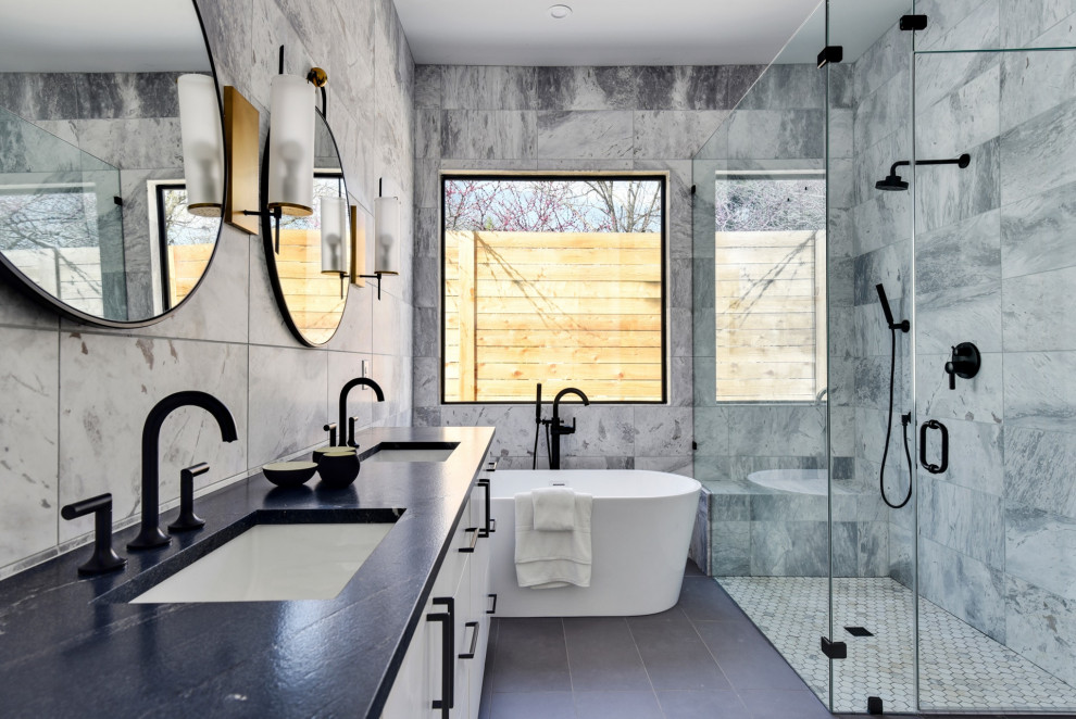 Inspiration för ett funkis svart svart en-suite badrum, med släta luckor, vita skåp, ett fristående badkar, en kantlös dusch, flerfärgad kakel, marmorkakel, ett undermonterad handfat, granitbänkskiva, grått golv och dusch med gångjärnsdörr