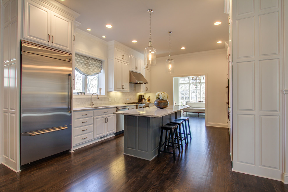 Design ideas for a large traditional galley eat-in kitchen in Nashville with an undermount sink, raised-panel cabinets, white cabinets, marble benchtops, grey splashback, subway tile splashback, stainless steel appliances and dark hardwood floors.