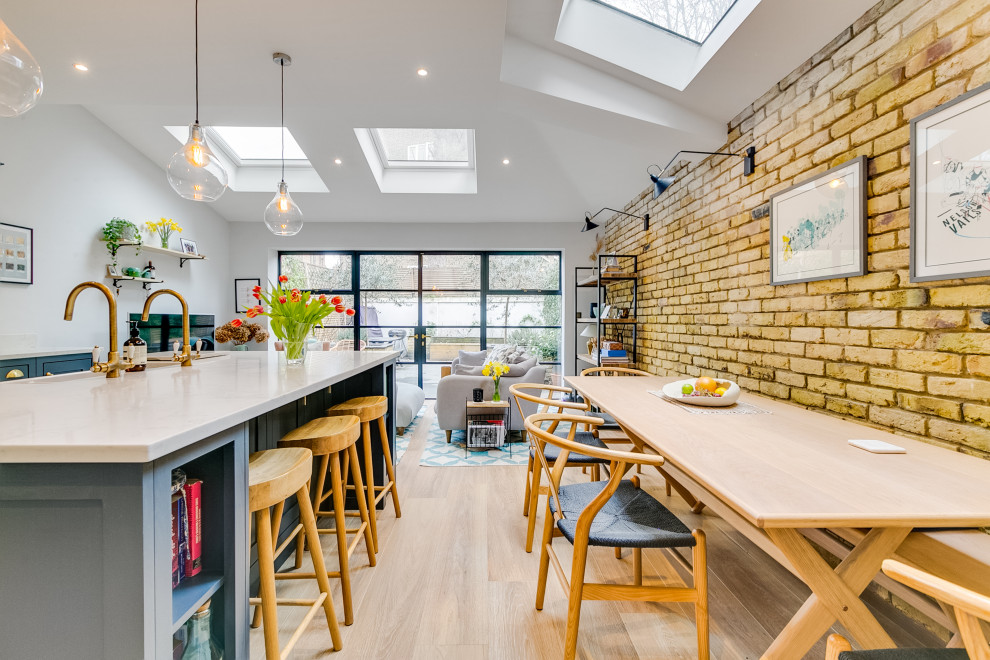 Photo of a small contemporary open plan dining in London with brick walls.