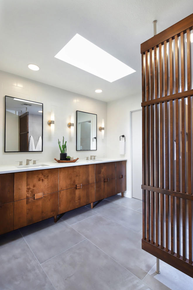 This is an example of a mid-sized midcentury master bathroom in Phoenix with flat-panel cabinets, medium wood cabinets, a curbless shower, a one-piece toilet, gray tile, porcelain tile, white walls, porcelain floors, an undermount sink, engineered quartz benchtops, grey floor, an open shower, white benchtops, a niche, a double vanity, a built-in vanity and wood walls.