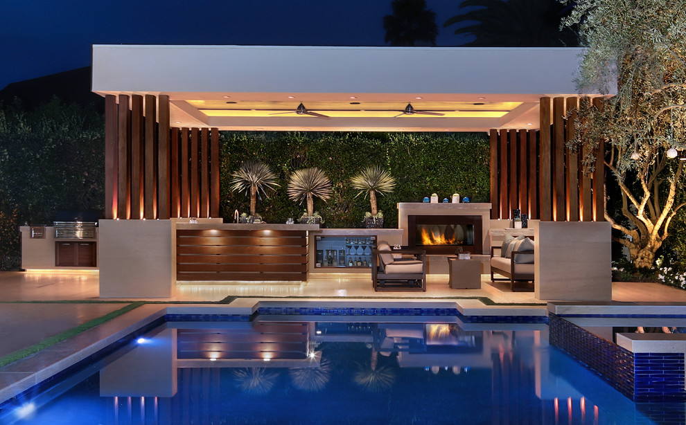 This is an example of a large contemporary backyard rectangular pool in Orange County with natural stone pavers.