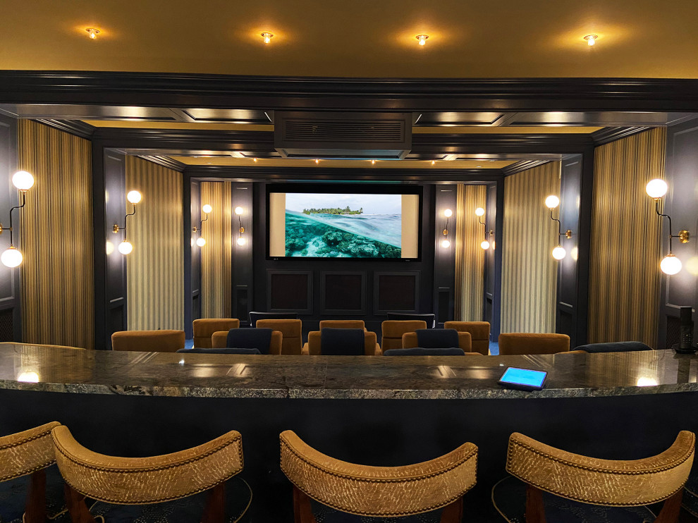 Cette image montre une salle de cinéma traditionnelle avec un mur beige, moquette, un écran de projection et un sol bleu.