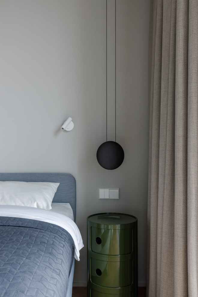 На фото: хозяйская спальня среднего размера в современном стиле с серыми стенами, паркетным полом среднего тона, коричневым полом и рабочим местом без камина с