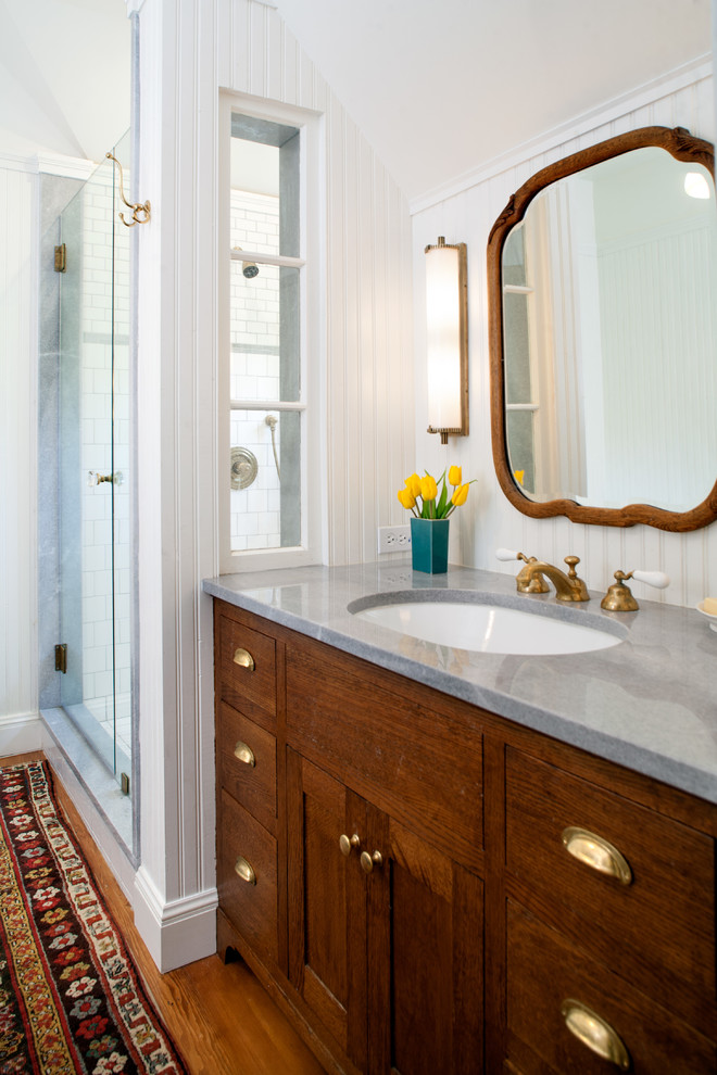 Alcove shower - mid-sized country master white tile medium tone wood floor alcove shower idea in Los Angeles with an undermount sink, shaker cabinets, dark wood cabinets, marble countertops, white walls and gray countertops