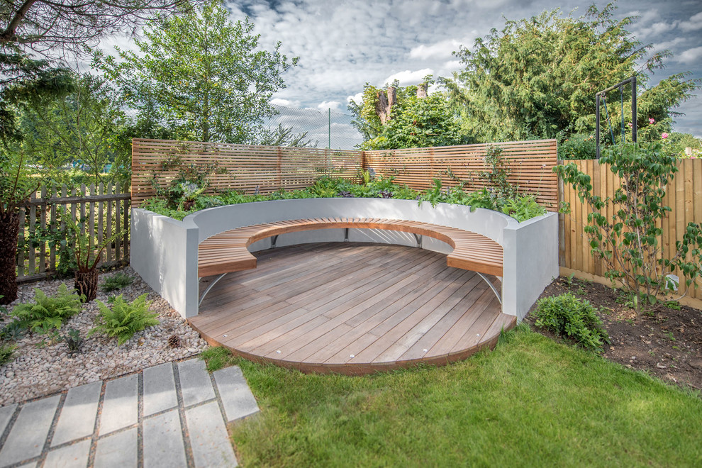 This is an example of a large contemporary backyard deck in London with no cover.